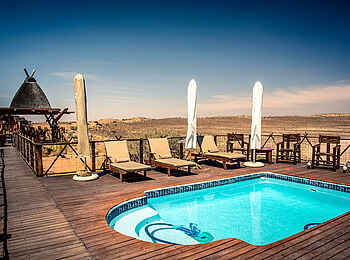 !Xaus Lodge: Pool mit Liegestühlen !Xaus Lodge: Pool mit Liegestühlen