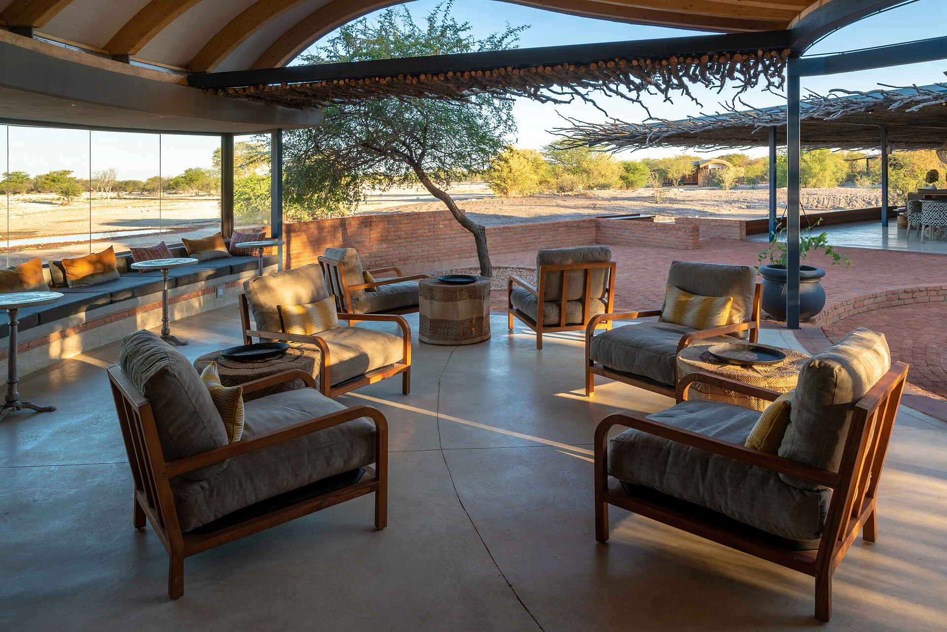 Afrikarma, Afrikarma Safaris, Afrikarma Safaris - Wildnis. Hautnah., Afrikarma.de, Anderssons At Ongava, Bäume, Blumentöpfe, Büsche, Holzbalken, Holzdach, Kissen, Ornamente, Sessel, Tische