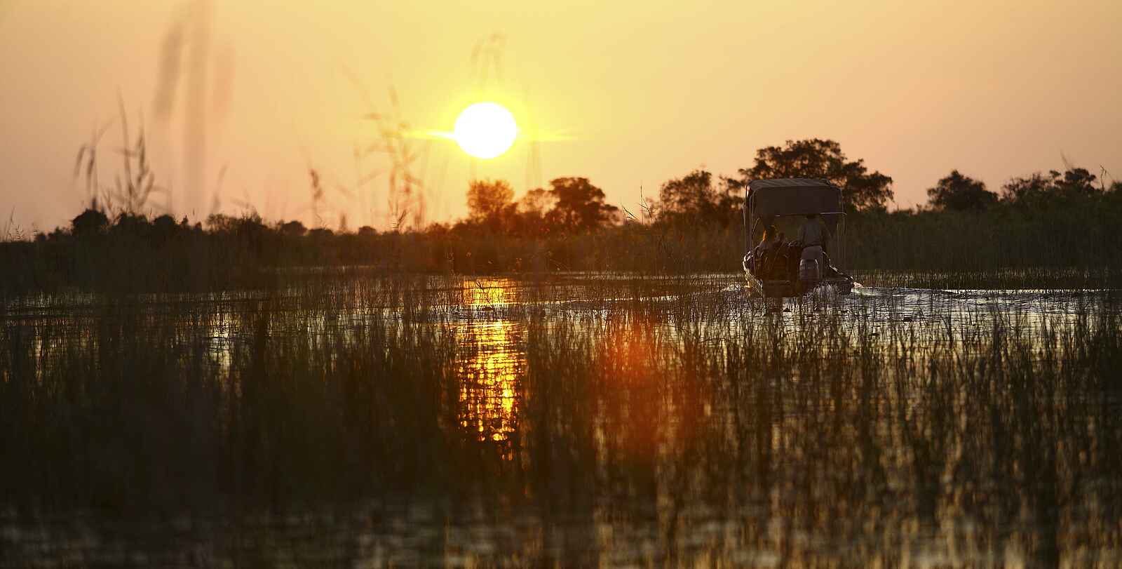 Nxabega Okavango Tented Camp: Sonnenuntergang mit Boot Nxabega Okavango Tented Camp: Sonnenuntergang mit Boot