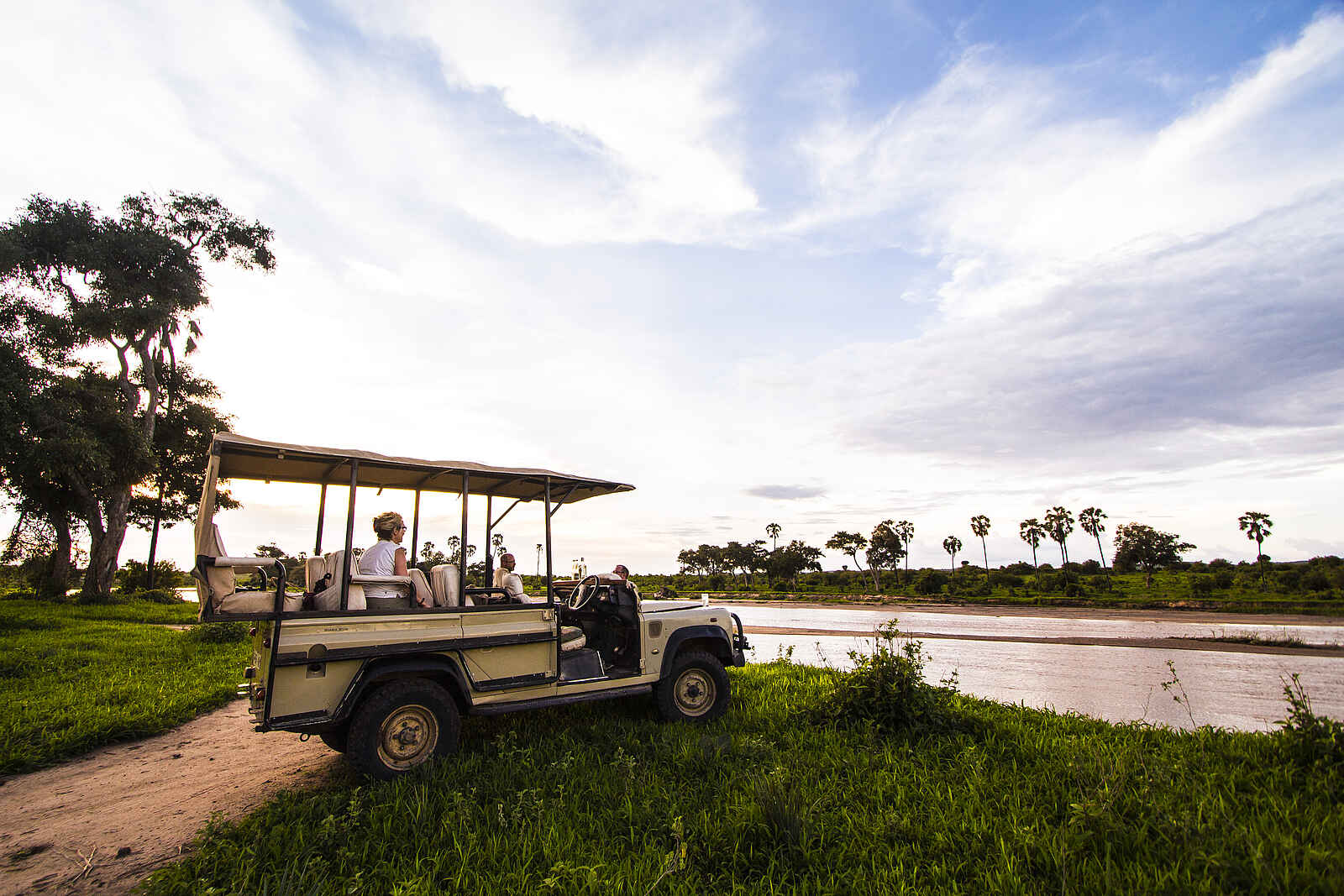 Kwihala Camp: Safarifahrzeug am Fluss Kwihala Camp: Safarifahrzeug am Fluss