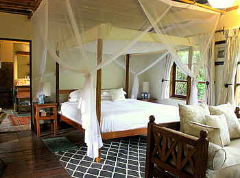 Volcanoes Bwindi Lodge: Sofa, Bett und Badezimmer