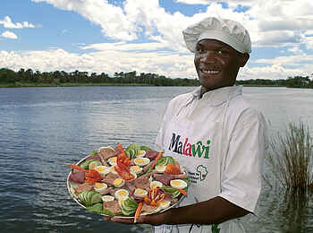 Mvuu Camp: Koch mit Speisen