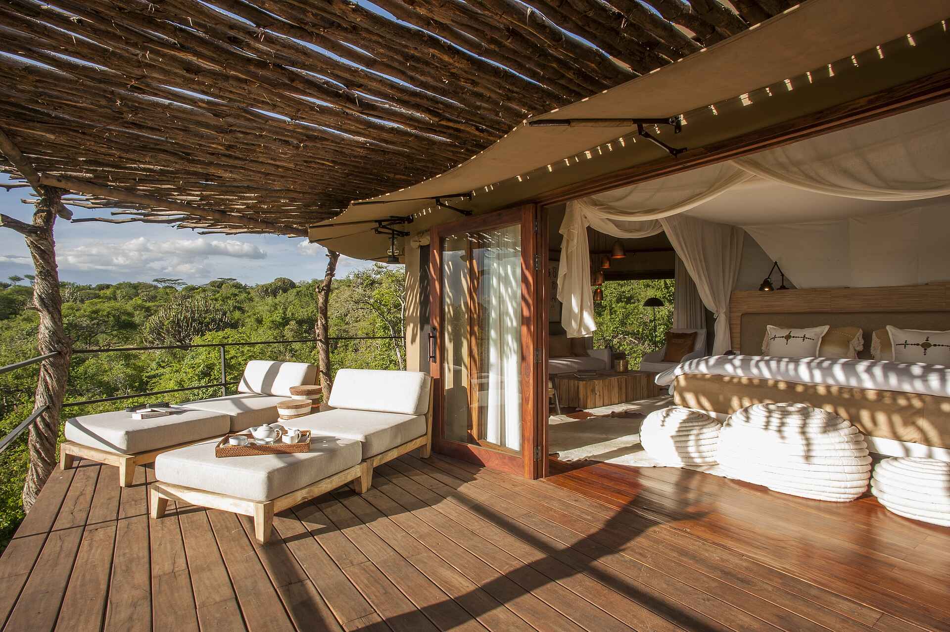 Friedkin Conservation Fund, Legendary Expeditions, Legendary Mwiba Lodge, Mwiba Wildlife Reserve, Afrikarma, Afrikarma Safaris, Afrikarma Safaris. Wildnis. Hautnah., Afrikarma.de, Gästeunterkunft, Zeltsuite, Doppelbett, Holzfußboden, Liegestuhl, Veranda