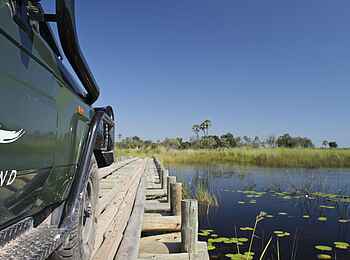 Nxabega Okavango Tented Camp: Safarifahrzeug auf Holzbrücke