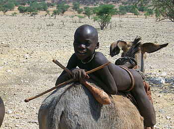 Fort Sesfontein: Ein Himba-Junge auf einem Esel