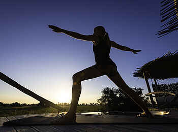 Mombo Camp: Yoga auf dem Holzdeck Mombo Camp: Yoga auf dem Holzdeck