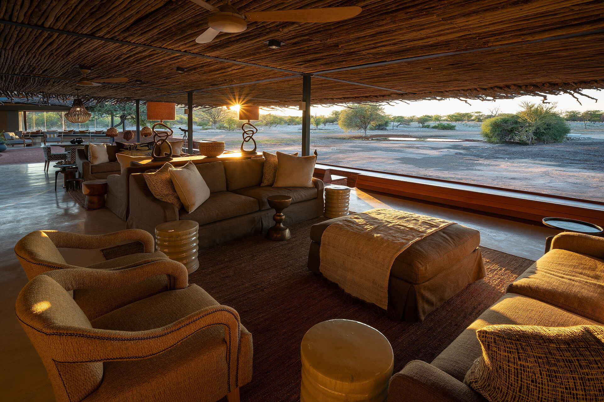 Afrikarma, Afrikarma Safaris, Afrikarma Safaris - Wildnis. Hautnah., Afrikarma.de, Anderssons At Ongava, Bäume, Büsche, Deckenventilator, Holzdach, Kissen, Ornamente, Sofa, Sofasitze, Teppichläufer, Tische