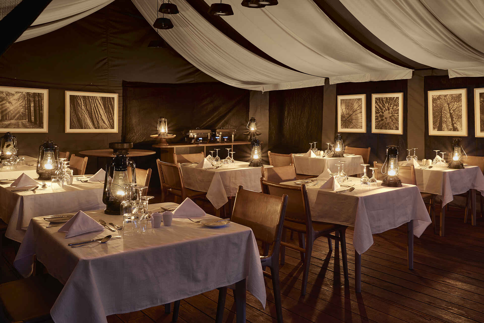 Sanctuary Ngorongoro Crater Camp: Speisesaal Afrikarma, Afrikarma Safaris, Afrikarma Safaris - Wildnis. Hautnah., Afrikarma.de, Sanctuary Ngorongoro Crater Camp, Besteck, Bilder, Gläser, Holzboden, Paraffinlampen, Servietten, Stühle, Teller, Tischdecken, Tische