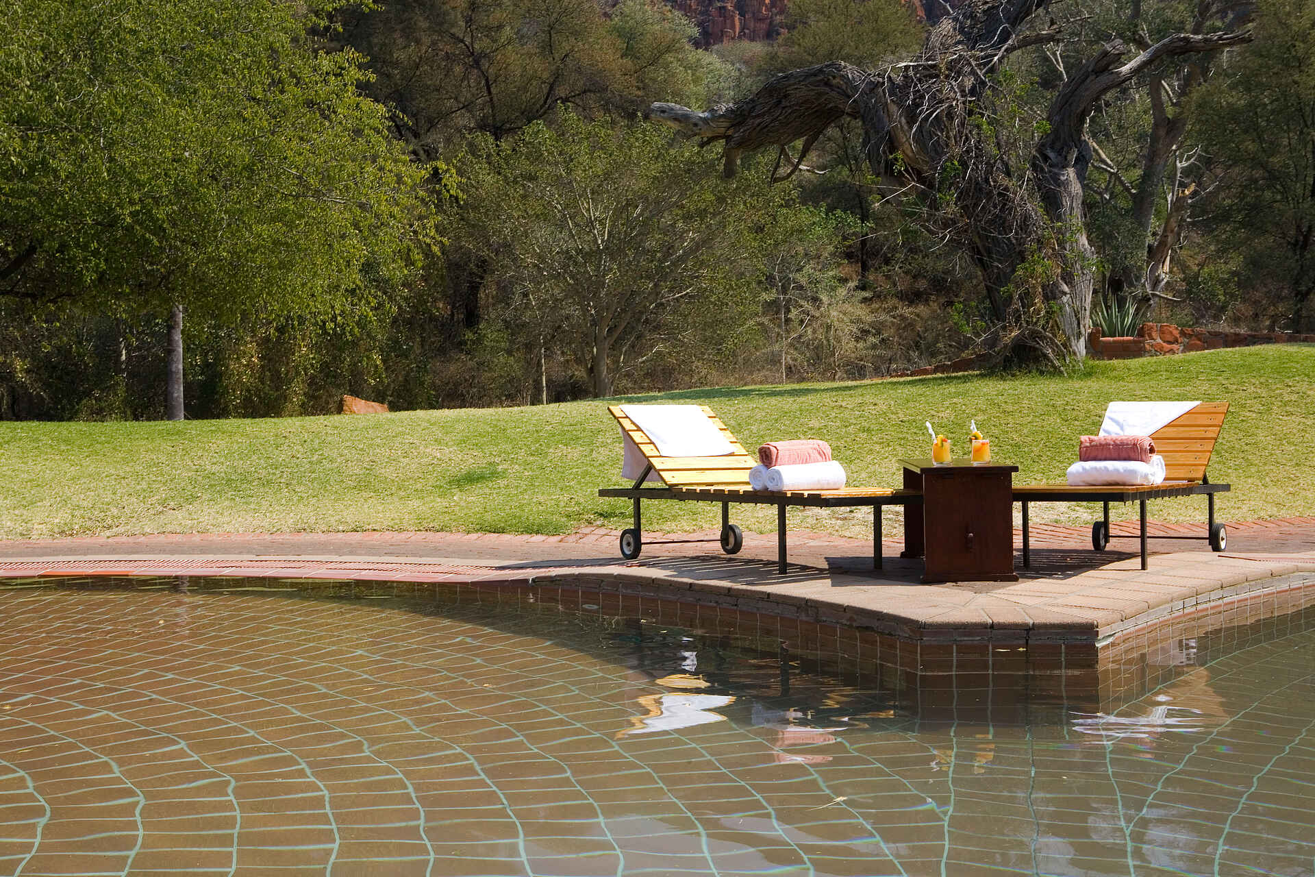 Waterberg Restcamp: Sonnenliegen am Wasser Namibia, Namibia Wildlife Resorts, Otjiwarongo, Waterberg Camp, Waterberg Plateau, Aussenanlage, Entspannung, Garten, Wasser, Afrikarma, Afrikarma Safaris, Afrikarma Safaris - Wildnis. Hautnah., afrikarma.de