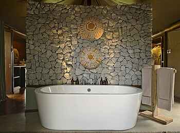 &Beyond Ngala Tented Camp: Badewanne vor Steinwand