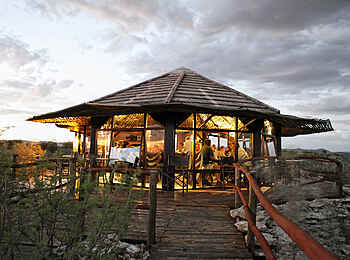Vingerklip Lodge: Das beleuchtete Eagle's Nest Restaurant in der Gesamtansicht mit umgebender Sonnenterrasse