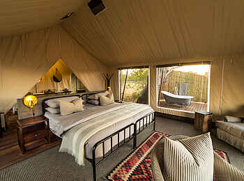 Little Machaba Camp: Innenansicht eines Gästezeltes mit Durchgang zum Bad im Hintergrund