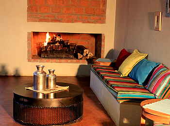 Chameleon Hills Lodge: Eine plauschige Sitzbank vor dem Kamin