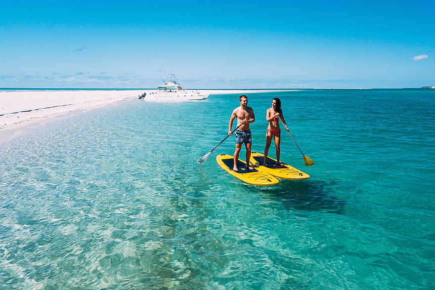 Santorini Mozambique: Ein Paar beim Stand-up-Paddeln Santorini Mozambique: Ein Paar beim Stand-up-Paddeln