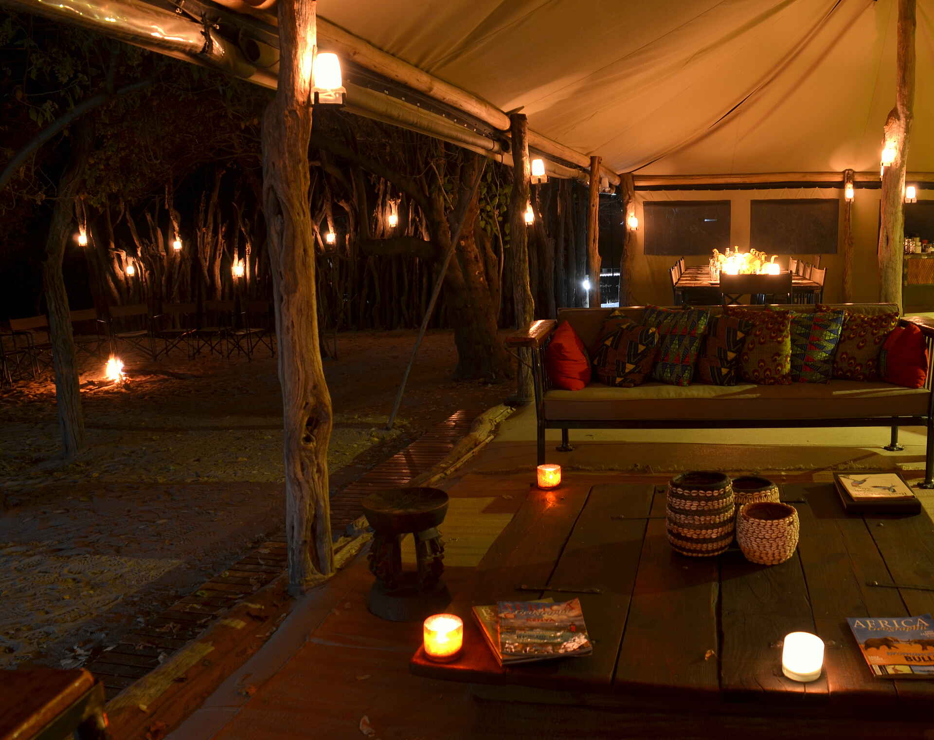Sango Safari Camp: Abend im Hauptzelt Bush Ways, Khwai River, Moremi Game Reserve, NG 19, Okavango-Delta, Sango Safari Camp, Abendessen, Hauptzelt, Kerzen, Lounge, Service, Sessel, Sitzgruppe, Sofa, Afrikarma, Afrikarma Safaris, Afrikarma Safaris - Wildnis. Hautnah., Afrikarma.de