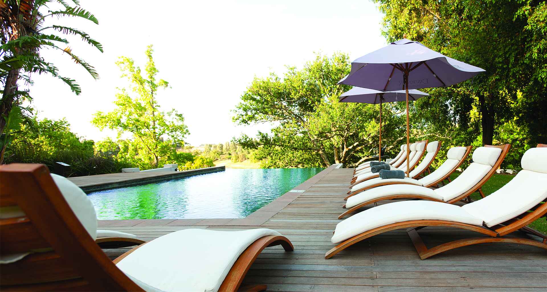 Afrikarma, Afrikarma Safaris, Afrikarma Safaris - Wildnis. Hautnah., Afrikarma.de, L'Avenir Country Lodge, Bäume, Handtücher, Liegestühle, Pooldeck, Sonnenschirme, Swimmingpool