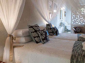 Bayete Guest Lodge: Bett und Blick ins Badezimmer