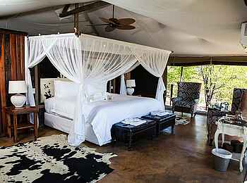 Camp Kuzuma: Doppelbett und Kuhhäute am Boden Camp Kuzuma: Doppelbett und Kuhhäute am Boden