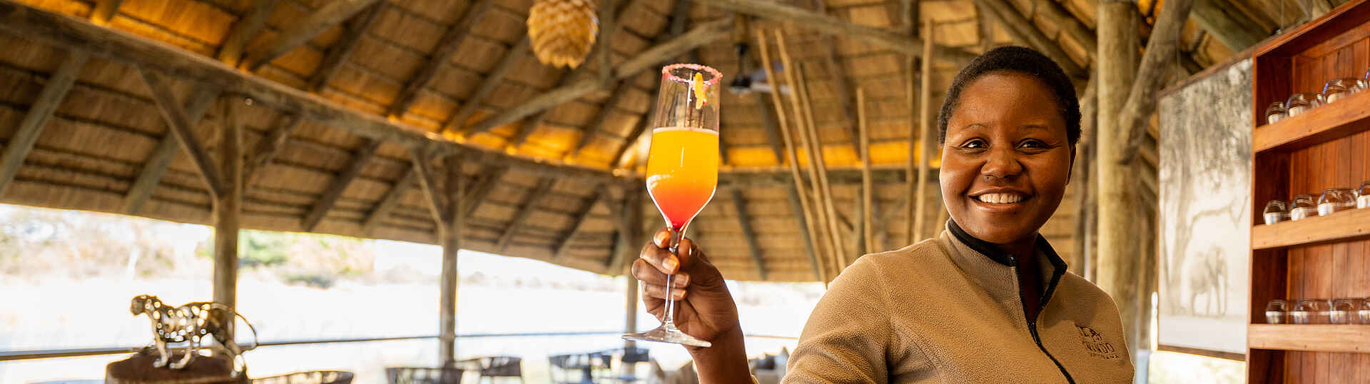 Eine Mitarbeiterin des 4 River Camps präsentiert einen Drink