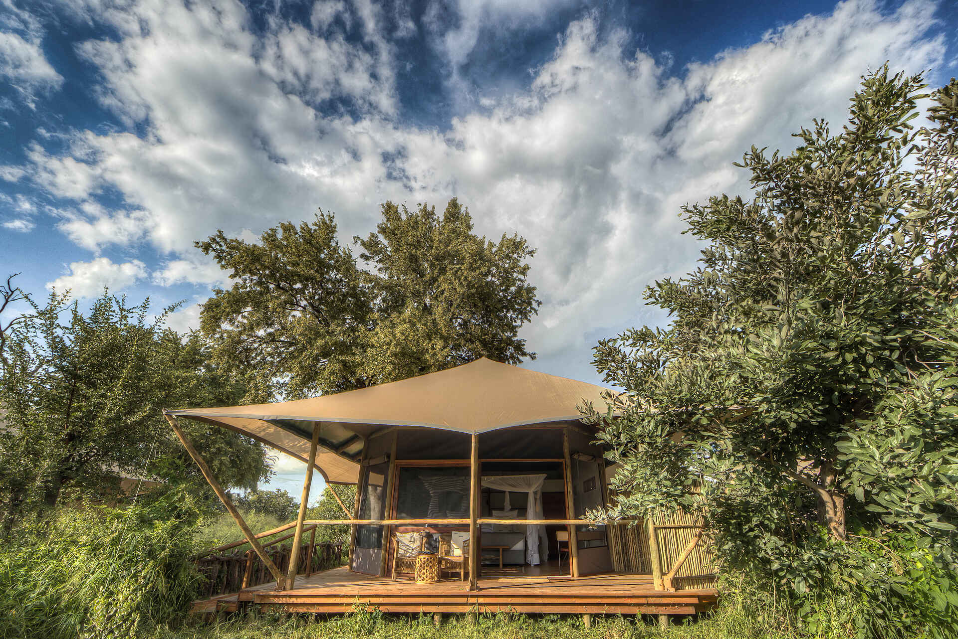 Afrikarma, Afrikarma Safaris, Afrikarma Safaris. Wildnis. Hautnah., Afrikarma.de, Bäume, Busch, Doppelbett, Fenster, grün, Treppe, Tür, Zaun, Zelt