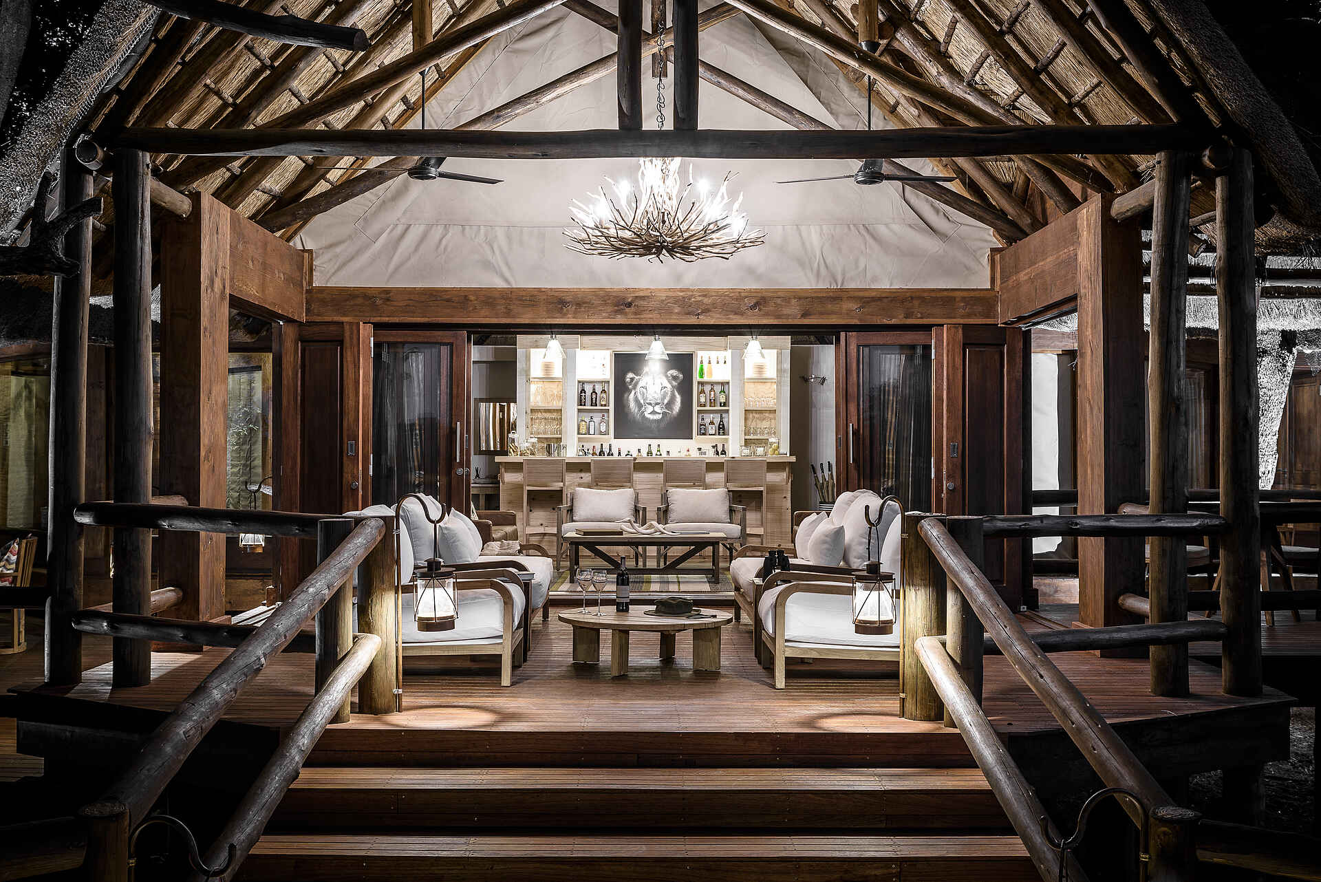 Barstühle, Bartheke, Flaschen, Holzbalken, Holzboden, Lampen, Ornamente, Paraffinlampen, Sofasitze, Strohdach, Tische, Treppen, Sanctuary Chief's Camp Geoffrey Kent Suite, Afrikarma, Afrikarma Safaris, Afrikarma Safaris - Wildnis. Hautnah., Afrikarma.de