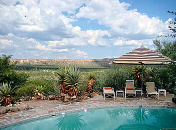 Vingerklip Lodge: Swimmingpool mit Liegen und Blick auf die Ugab Terrassen