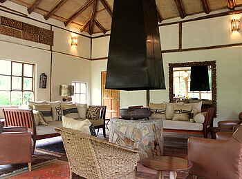 Volcanoes Bwindi Lodge: Die Main Lounge mit Kamin und Sofas