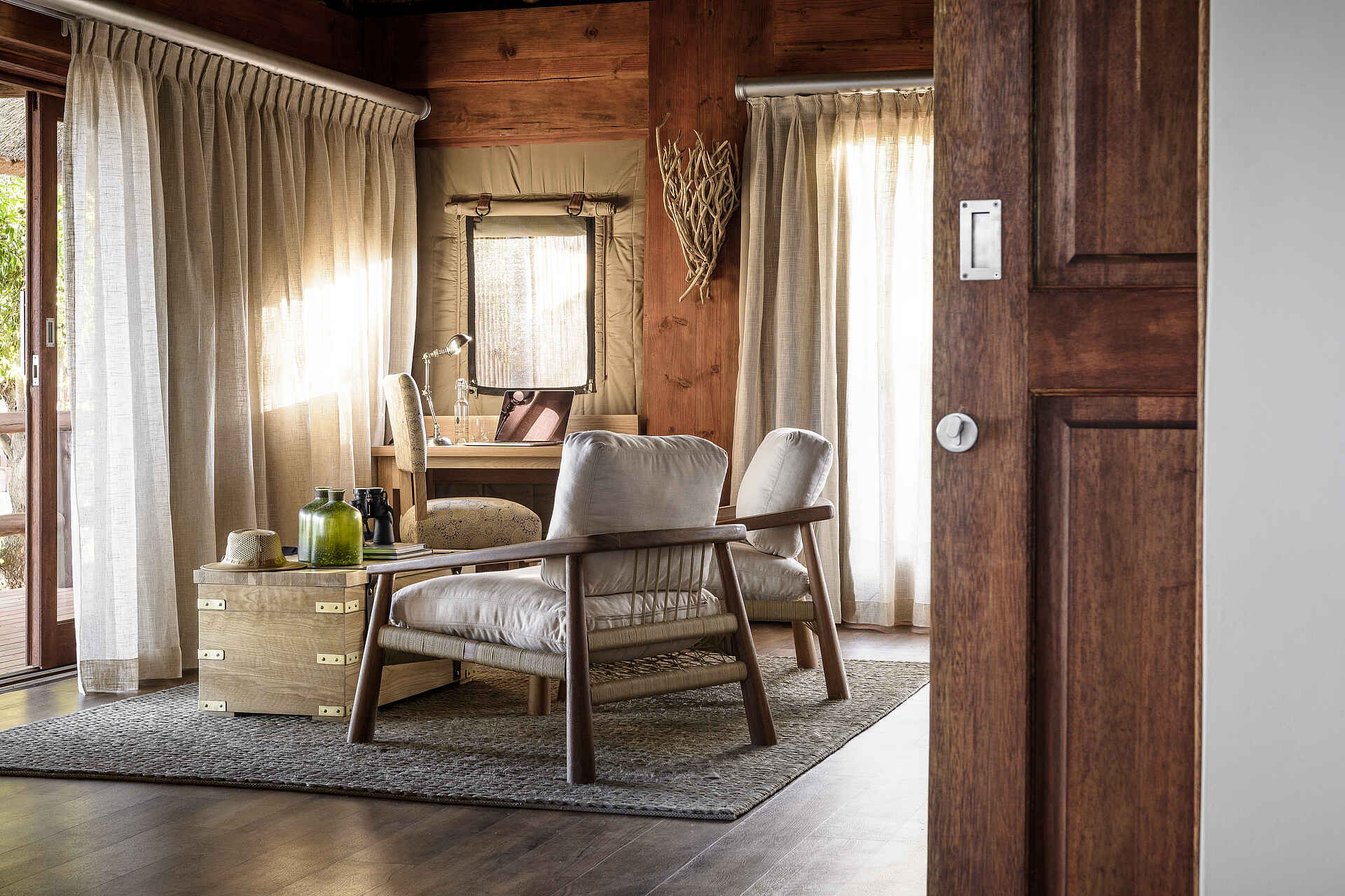 Afrikarma, Afrikarma Safaris, Afrikarma Safaris - Wildnis. Hautnah., Afrikarma.de, Sanctuary Chief's Camp, Flaschen, Hut, Ornamente, Sofasitze, Teppich, Tisch, Tür, Vorhänge