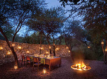 Morukuru River House: Essbereich in der Boma in der Abenddämmerung Morukuru River House: Essbereich in der Boma in der Abenddämmerung