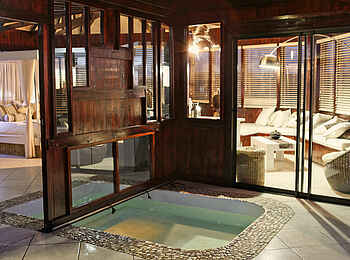 Vingerklip Lodge: Der beleuchtete Innenbereich des Heaven's Gate Luxuschalets mit Pool, Bett, Wohnbereich und Trennwänden