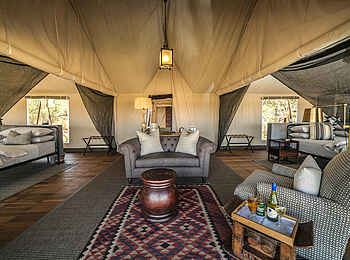 Little Machaba Camp: Gemütliche Lounge eines Familienzeltes mit Schlafbereichen links und rechts