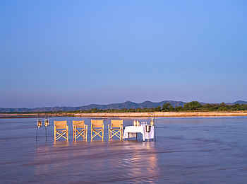 Zungulila Bushcamp: Sundowner im flachen Luangwawasser Zungulila Bushcamp: Sundowner im flachen Luangwawasser