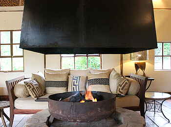 Volcanoes Bwindi Lodge: Ein Feuer prasselt im Kaminzimmer